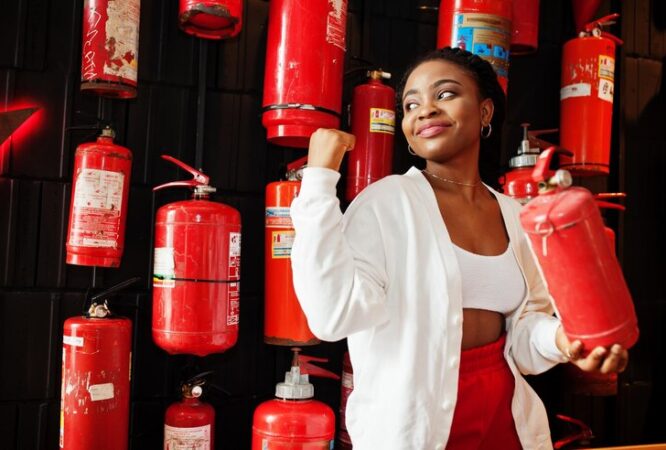 african-woman-posed-against-wall-with-old-extinguisher_627829-12292