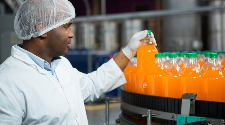 male-worker-checking-juice-bottles-factory_107420-96531