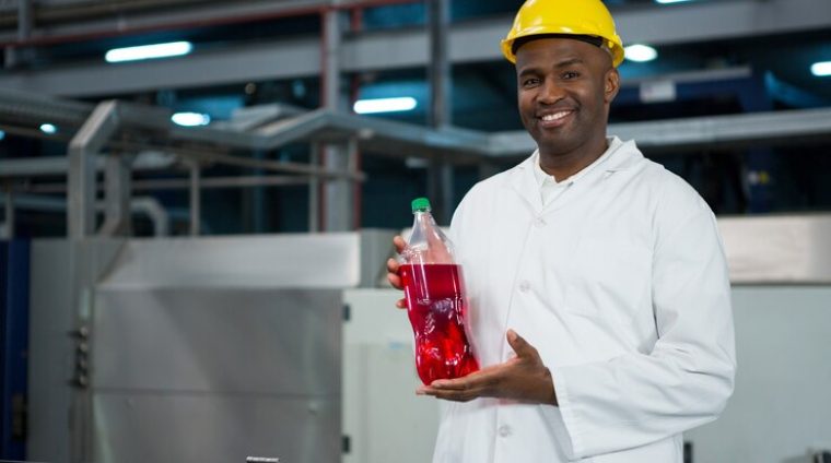 male-worker-showing-juice-bottle-factory_107420-96061