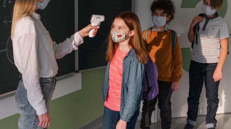 female-teacher-with-medical-mask-checking-children-s-temperature-school_23-2148848279