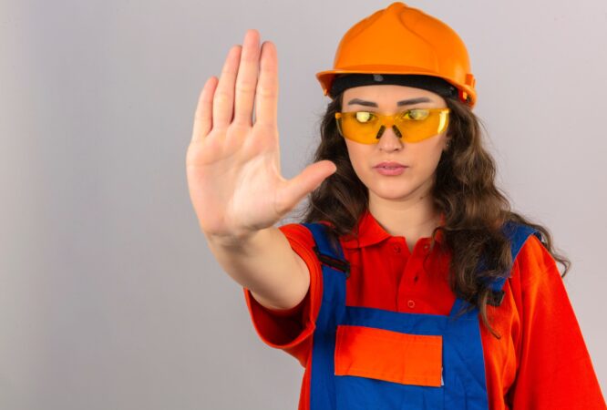 young-builder-woman-construction-uniform-yellow-glasses-safety-helmet-doing-stop-sing-with-palm-hand-warning-expression-isolated-white-wall_141793-16274